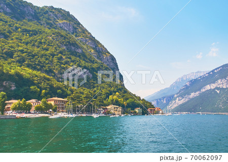 Steep alpine banks of beautiful lake Como with parked boats and yachts near village of Pare, Italy 70062097