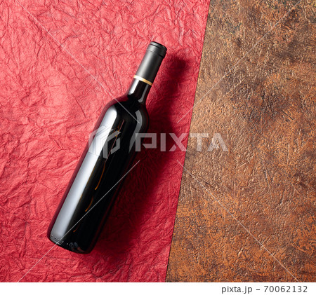 A bottle of red wine on an old rough background. A bottle of red wine on an old rough background. 70062132