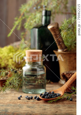 Juniper tincture and juniper berries on an old wooden table. Juniper tincture and juniper berries on an old wooden table. 70062215
