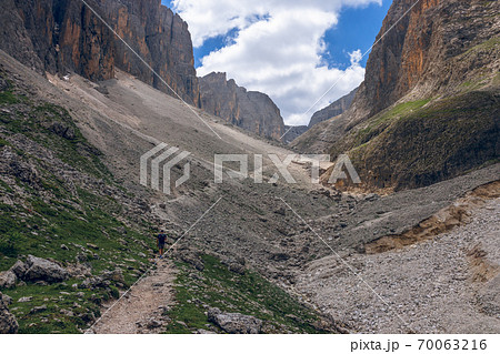 A man walks along a path in the Italian Alps 70063216