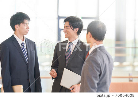立ち話をするスーツ姿のビジネスマンの写真素材