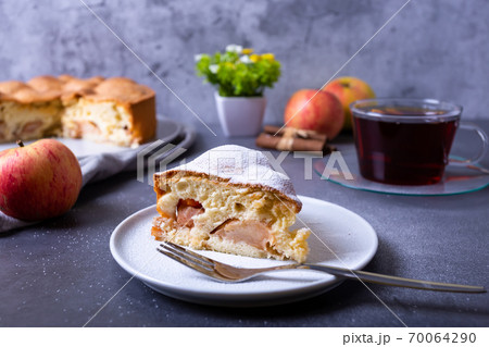 Apple pie Charlotte sprinkled with powdered sugar. A traditional biscuit cake with apples and cinnamon. Close-up. Apple pie Charlotte sprinkled with powdered sugar. A traditional biscuit cake with apples and cinnamon. Close-up. 70064290