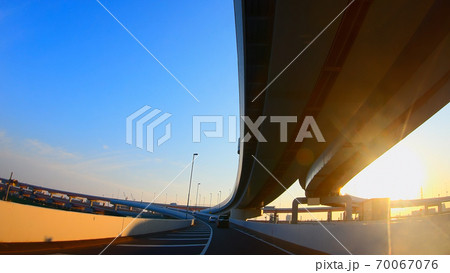 太陽の光が綺麗な高速道路を走る車の運転席からの景色 70067076
