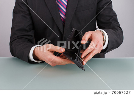 Business person holding an empty wallet. Business person holding an empty wallet. 70067527