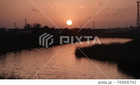 川の向こうに沈んでいく夕日 川の向こうに沈んでいく夕日 70068742