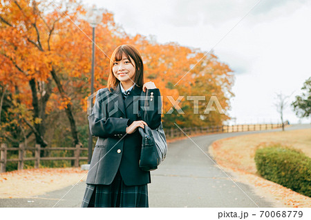 紅葉した街を歩く女子高生 70068779