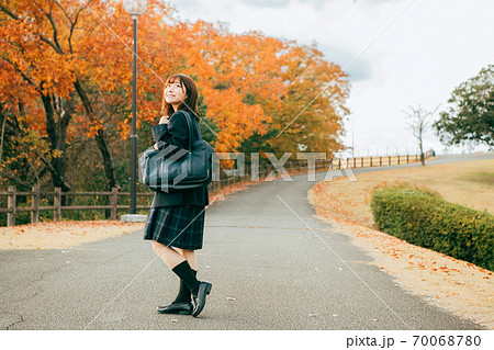 紅葉した街を歩く女子高生 70068780