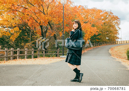 紅葉した街を歩く女子高生 70068781