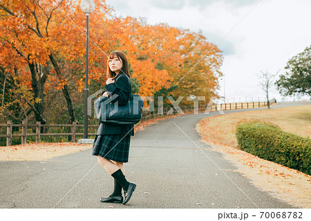 紅葉した街を歩く女子高生 70068782