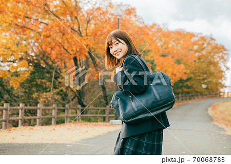 紅葉した街を歩く女子高生 70068783