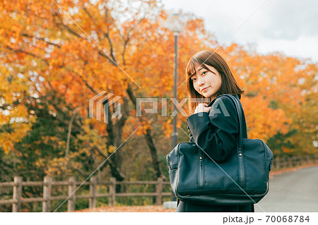 紅葉した街を歩く女子高生 70068784