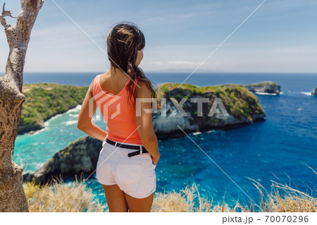 Traveller woman posing near Atuh beach and looks to ocean on Nusa Penida island, Indonesia. 70070296