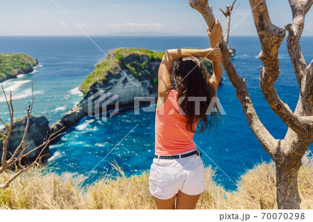 Traveller woman posing near Atuh beach and looks to ocean on Nusa Penida island, Indonesia. 70070298