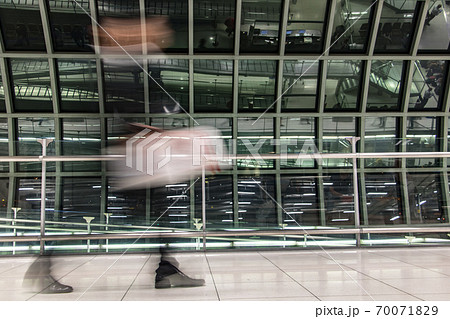 A man walking with luggage in blurred motion at airport hall.   70071829