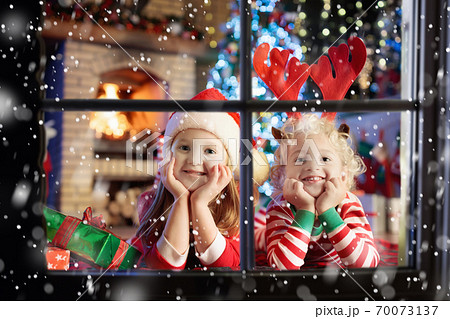 Child at Christmas tree. Kids at fireplace on Xmas 70073137