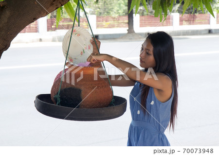 Woman taking water on a street Woman taking water on a street 70073948