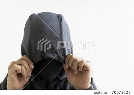 フードをかぶり マスクをつけた怪しい男性の写真素材