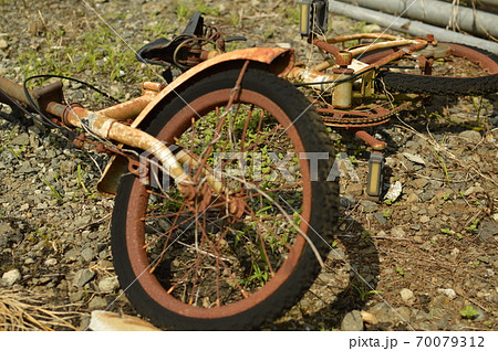 空き地に捨てられた自転車の写真素材