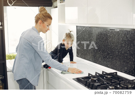Mom and daughter clean up in the kitchen Mom and daughter clean up in the kitchen 70082759