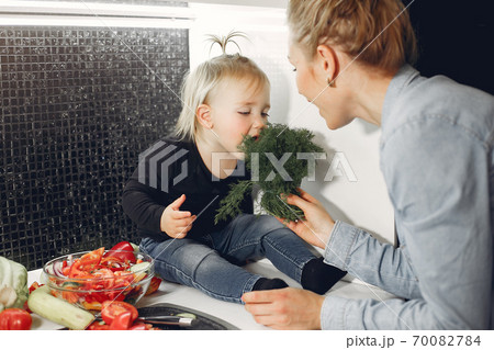 Beautiful family prepare food in a kitchen Beautiful family prepare food in a kitchen 70082784