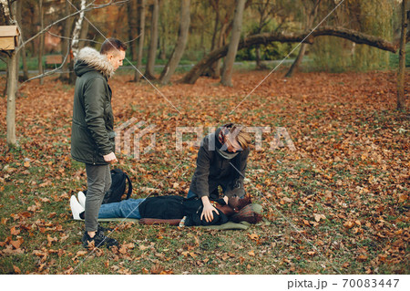 Two boys in a autumn park help a african girl 70083447
