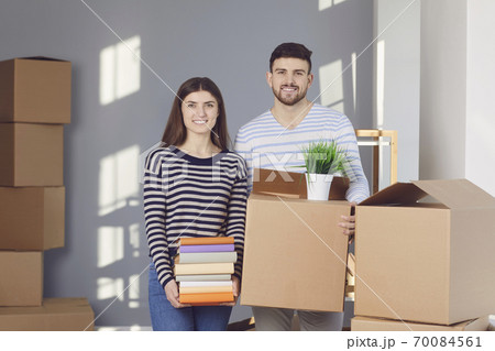 Young couple family with boxes to move in a new house room. 70084561