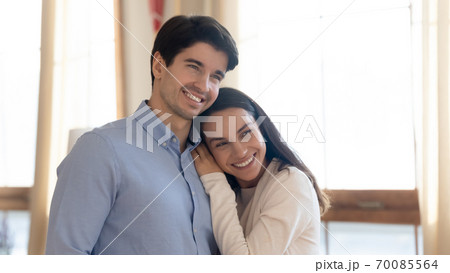 Happy newlyweds cuddling in new apartment and dreaming about future Happy newlyweds cuddling in new apartment and dreaming about future 70085564