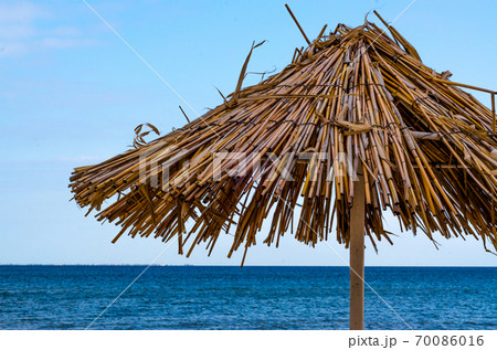 straw beach umbrella closeup on a clear day straw beach umbrella closeup on a clear day 70086016