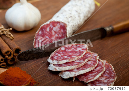 traditional Italian salame cured sausage sliced on a wood board traditional Italian salame cured sausage sliced on a wood board 70087912