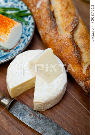 French cheese and fresh  baguette on a wood cutter 70087913