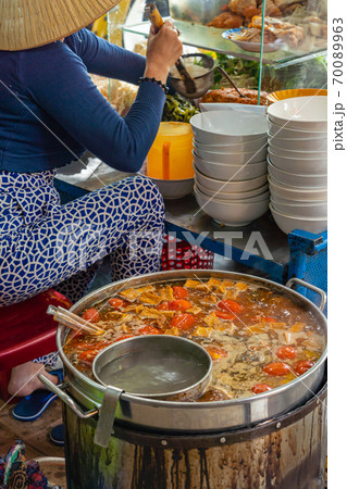 Woman cooking Bun Rieu, Vietnamese popular noodle soup at vendor Woman cooking Bun Rieu, Vietnamese popular noodle soup at vendor 70089963