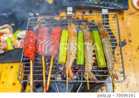 Barbecue shrimp skewers and marinated meat stick grilling on stove Barbecue shrimp skewers and marinated meat stick grilling on stove 70090161