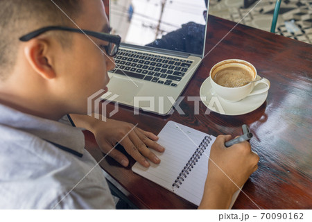 Asian student writing notes in the coffee shop Asian student writing notes in the coffee shop 70090162