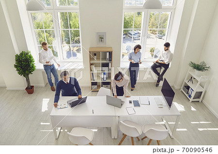 Serious young company employees preparing for corporate meeting in spacious office room 70090546