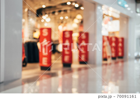 Red banners with SALE text at clothing store. Abstract blurred background of shopping mall interior Red banners with SALE text at clothing store. Abstract blurred background of shopping mall interior 70091161
