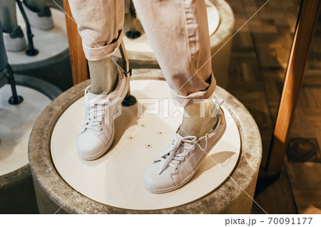 Mannequin legs in white leather sneakers on catwalk in shoe store, selective focus 70091177