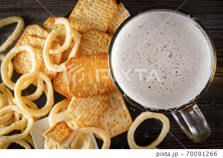 glass of beer and onion rings and a cracker , drink with snacks, top view, glass of beer and onion rings and a cracker , drink with snacks, top view, 70091266
