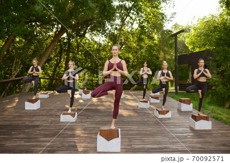 Women doing balance exercise, group yoga training 70092571