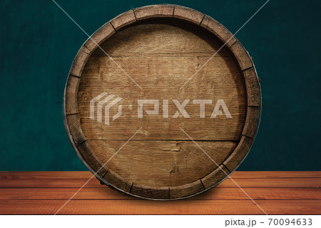 Beautiful wooden barrel on a red wood table and green wall background.. Beautiful wooden barrel on a red wood table and green wall background.. 70094633