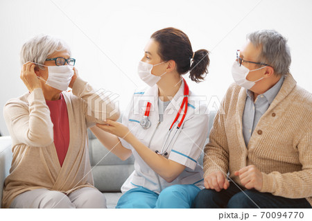 Doctor and senior couple wearing facemasks Doctor and senior couple wearing facemasks 70094770