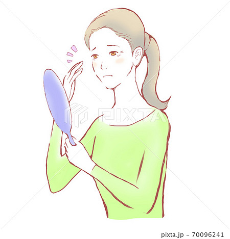 鏡を見ながら目元のシワに手をやって気にする女性 70096241