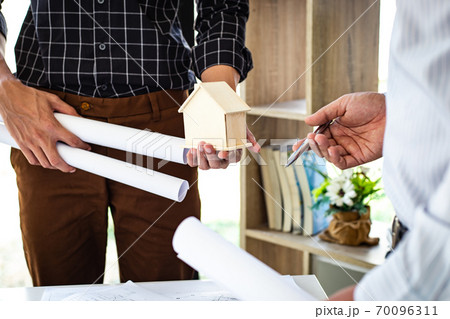 Engineers or architects are meeting a team to design the architectural structure in the design with blueprints and model buildings in working site, Technological structure and construction Concept. Engineers or architects are meeting a team to design the architectural structure in the design with blueprints and model buildings in working site, Technological structure and construction Concept. 70096311