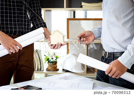 Engineers or architects are meeting a team to design the architectural structure in the design with blueprints and model buildings in working site, Technological structure and construction Concept. Engineers or architects are meeting a team to design the architectural structure in the design with blueprints and model buildings in working site, Technological structure and construction Concept. 70096312
