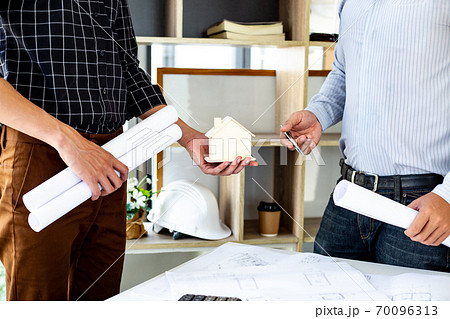 Engineers or architects are meeting a team to design the architectural structure in the design with blueprints and model buildings in working site, Technological structure and construction Concept. 70096313