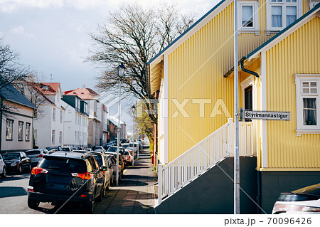 Yellow house with stairs and white railings, on the street in Reykjavik, the capital of Iceland. Cars parked along the road. Yellow house with stairs and white railings, on the street in Reykjavik, the capital of Iceland. Cars parked along the road. 70096426