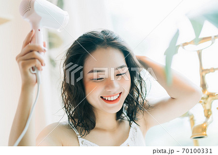 the woman is drying her hair 70100331