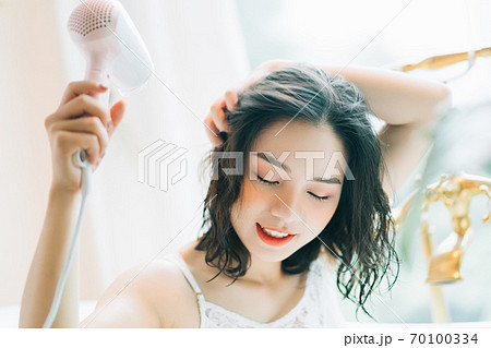 the woman is drying her hair the woman is drying her hair 70100334