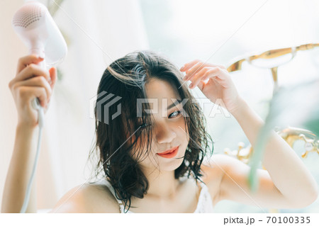 the woman is drying her hair 70100335