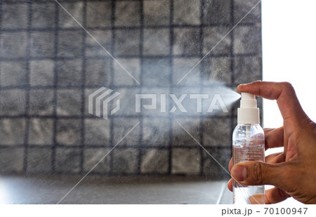 Man uses a spray of alcohol to get rid of bacteria and viruses, Inhibition and prevention of Covid-19 virus, protect virus concept. 70100947