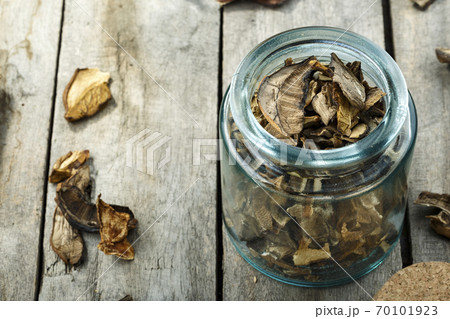 Dried mushrooms in a glass jar on a wooden table. 70101923